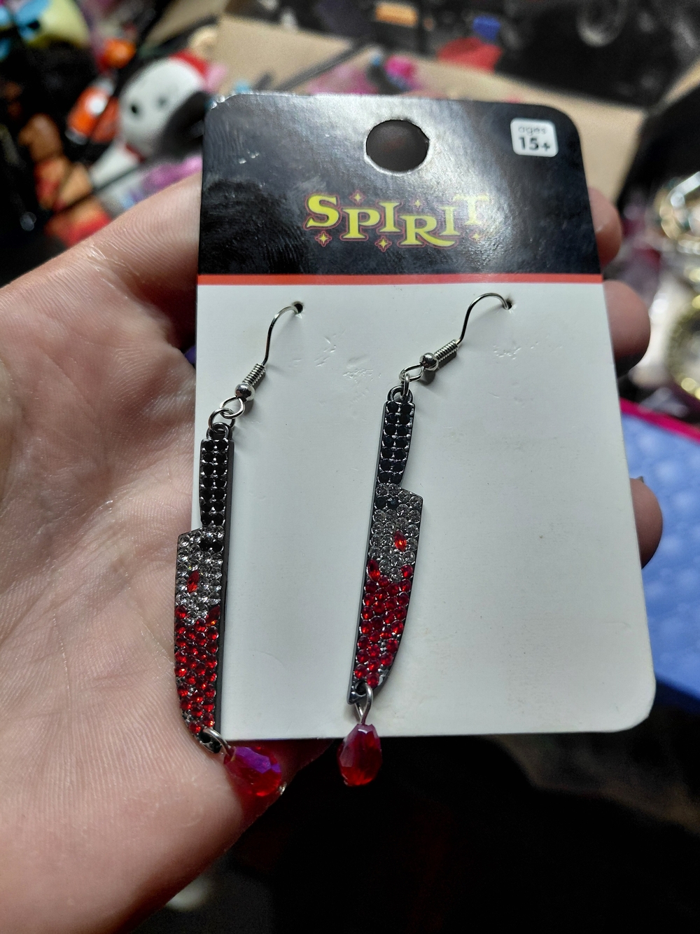 sparkly Spirit Halloween rhinestone knife earrings feature a fun, spooky design